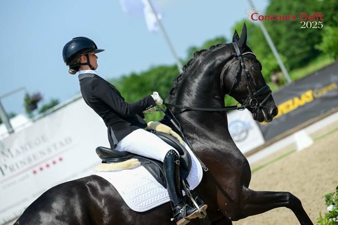 Devenda Dijkstra showing her horse in a young horse class at Concours Delft, wearing her JuulC competition jacket