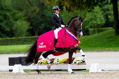 Renate van Uytert riding her black stallion in the prize-giving of the Pavo Cup, wearing her JuulC show coat 