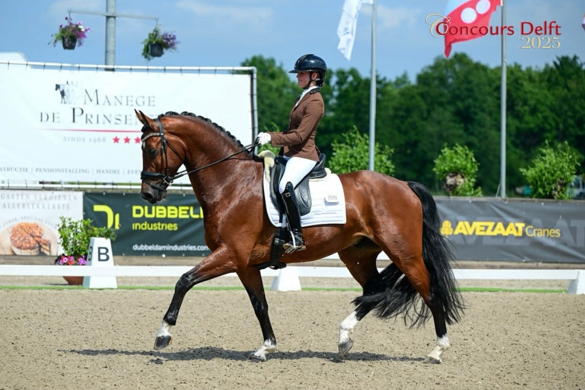 Devenda Dijkstra competing her horse at Concours Delft in a class for young dressage horses, wearing a JuulC show coat