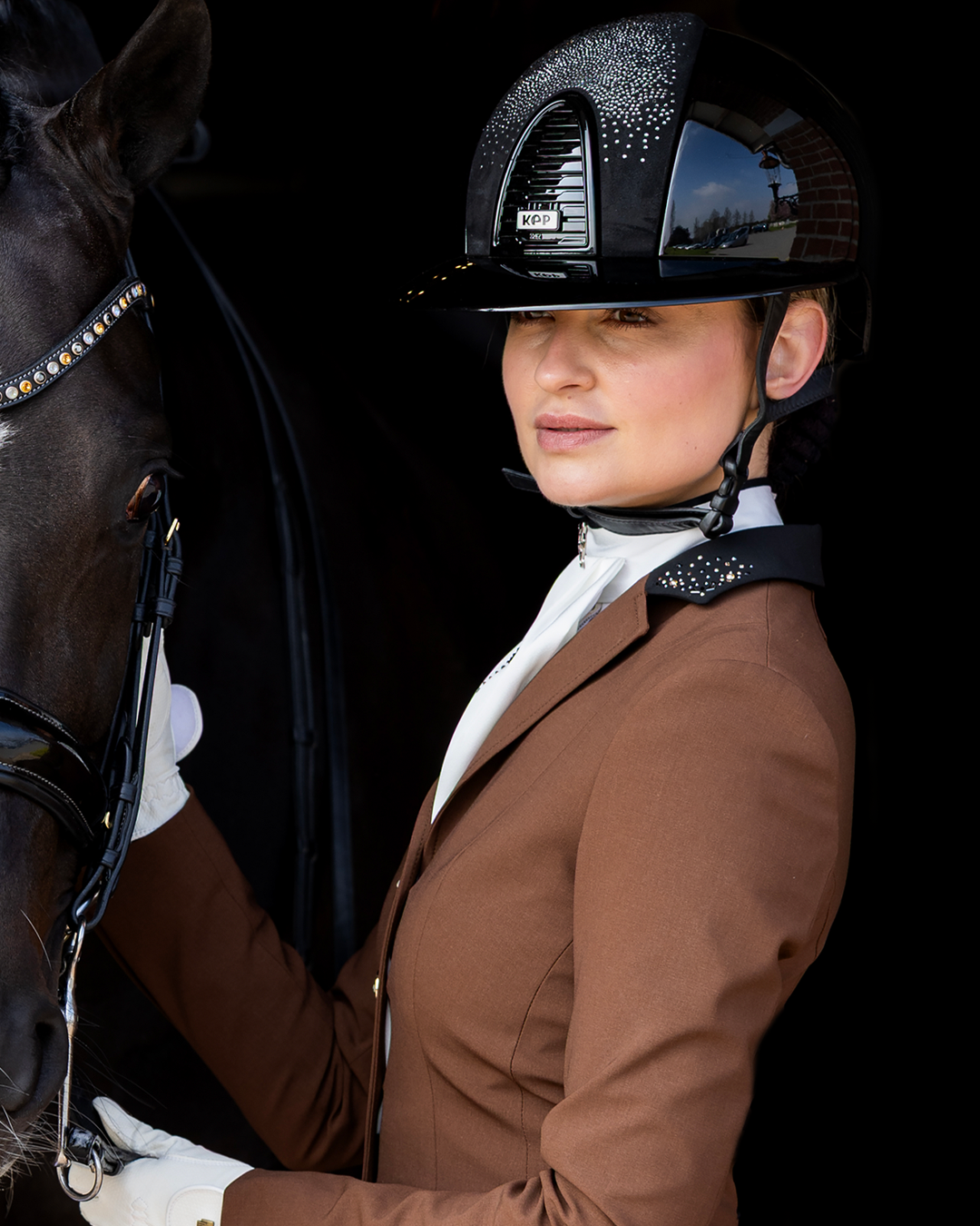 Side of model wearing brown JuulC' Ladies' Golden Espresso Show Coat with black contrasts and Swarovski details